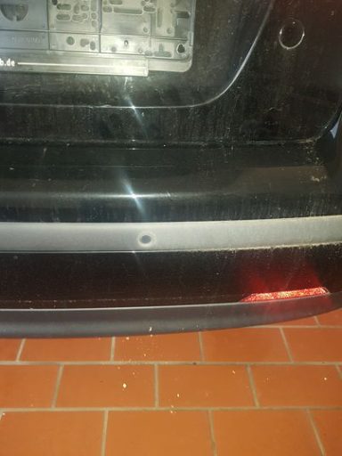 Trockeneis Reinigung Nahaufnahme einer Auto-Stoßstange mit Kratzern und Schmutz.